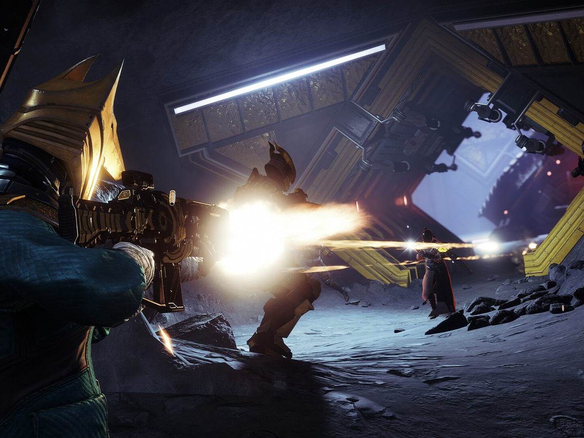 Un Guardián de Destiny 2 dispara un fusil en una galería oscura contra enemigos entre destellos