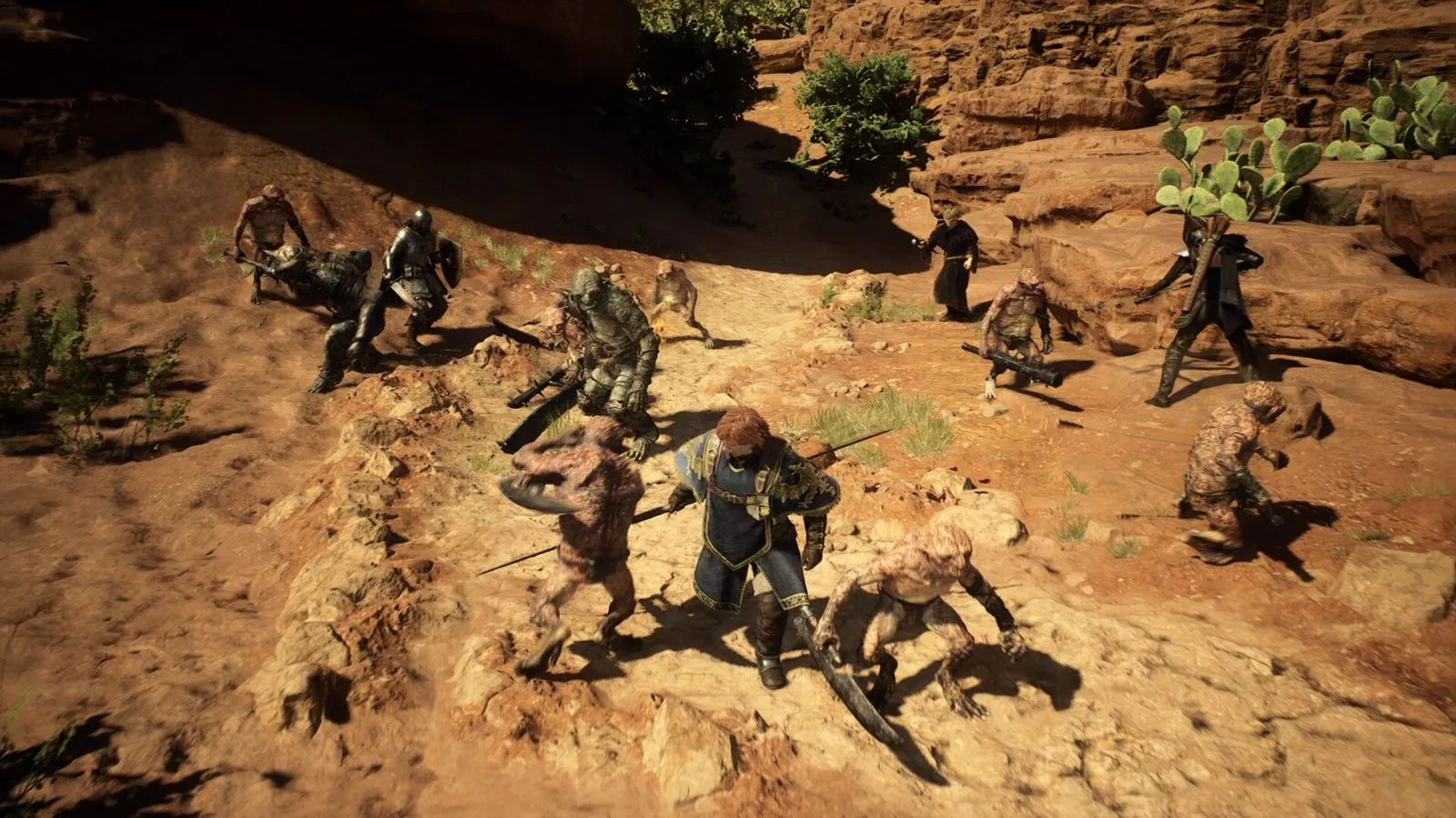 Un grupo de aventureros rodeado de goblins en un cañón de roca rojiza en Dragon's Dogma 2