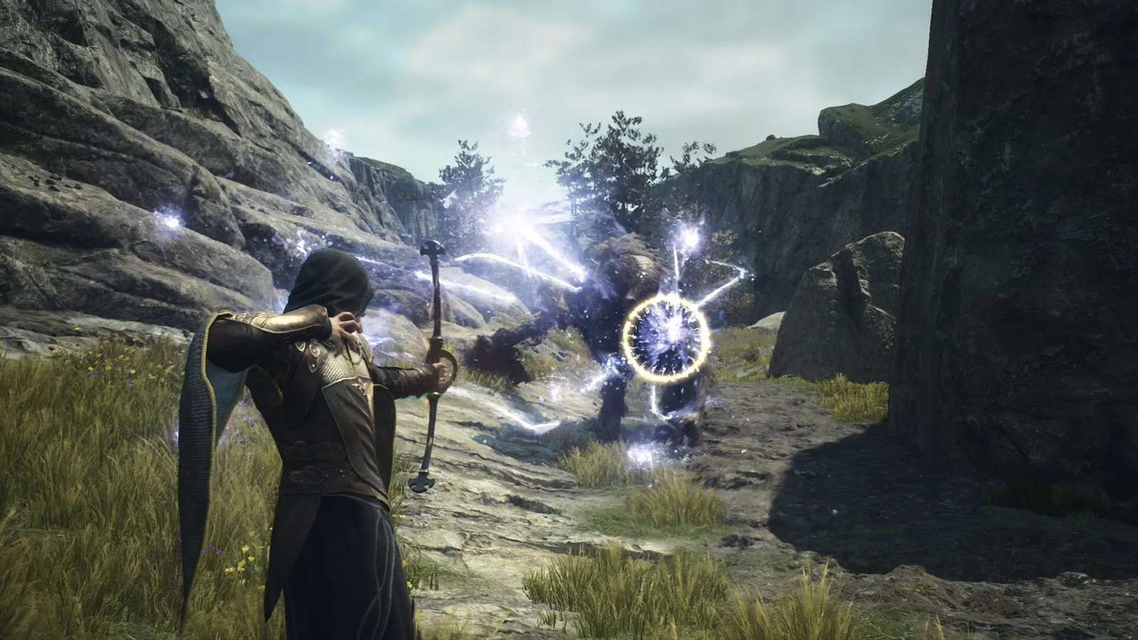 Una figura encapuchada dispara una flecha mágica contra un monstruo en un camino de montaña de Dragon's Dogma 2