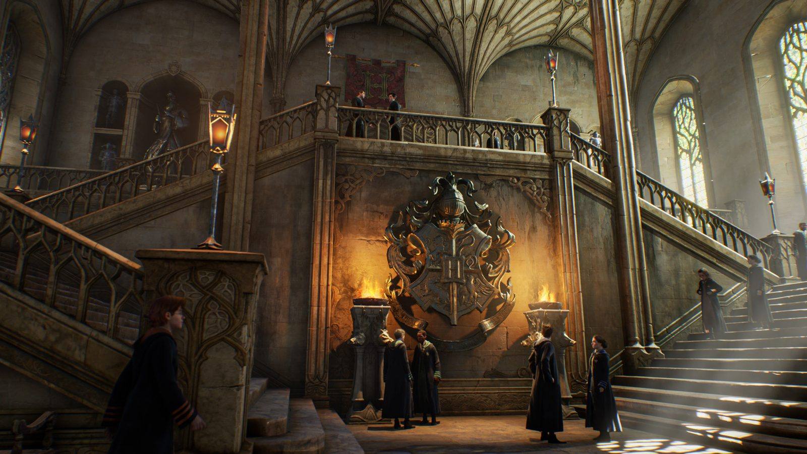 Escalinata de piedra de Hogwarts con el escudo del colegio en la pared, antorchas y estudiantes con túnica