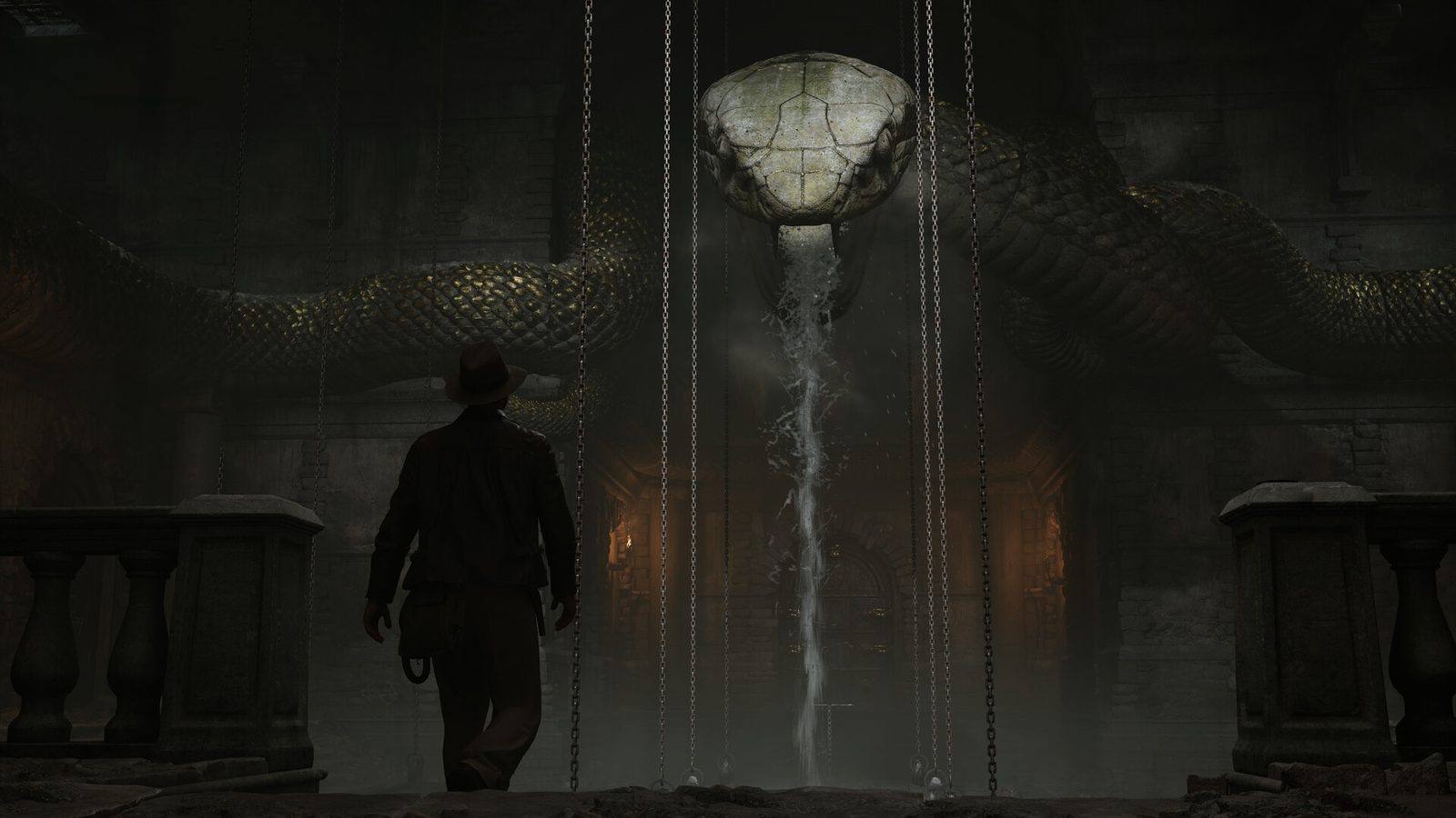 Indiana Jones visto de espaldas ante una enorme cabeza de serpiente de piedra de la que cae un chorro de agua, entre cadenas, en una sala oscura