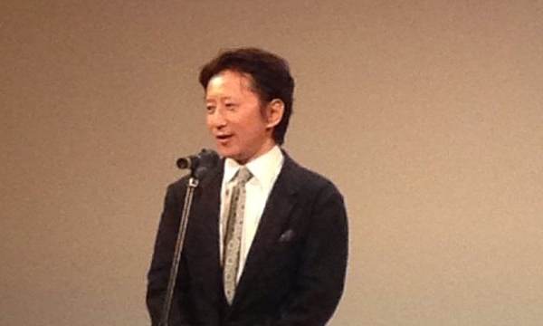 Hirohiko Araki, autor de JoJo's Bizarre Adventure, habla ante un micrófono en un acto en 2013, con traje oscuro y corbata clara