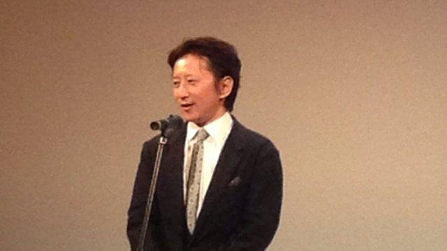 Hirohiko Araki, autor de JoJo's Bizarre Adventure, habla ante un micrófono en un acto en 2013, con traje oscuro y corbata clara
