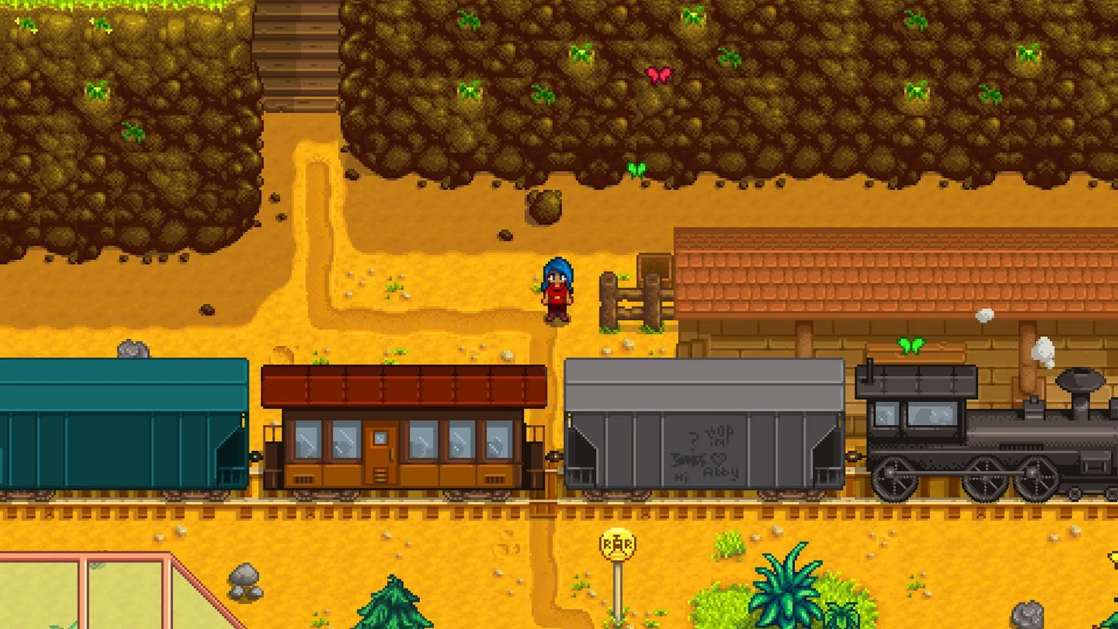 Un personaje de Stardew Valley frente a una estación con un tren de vagones azul, marrón y gris y una locomotora negra