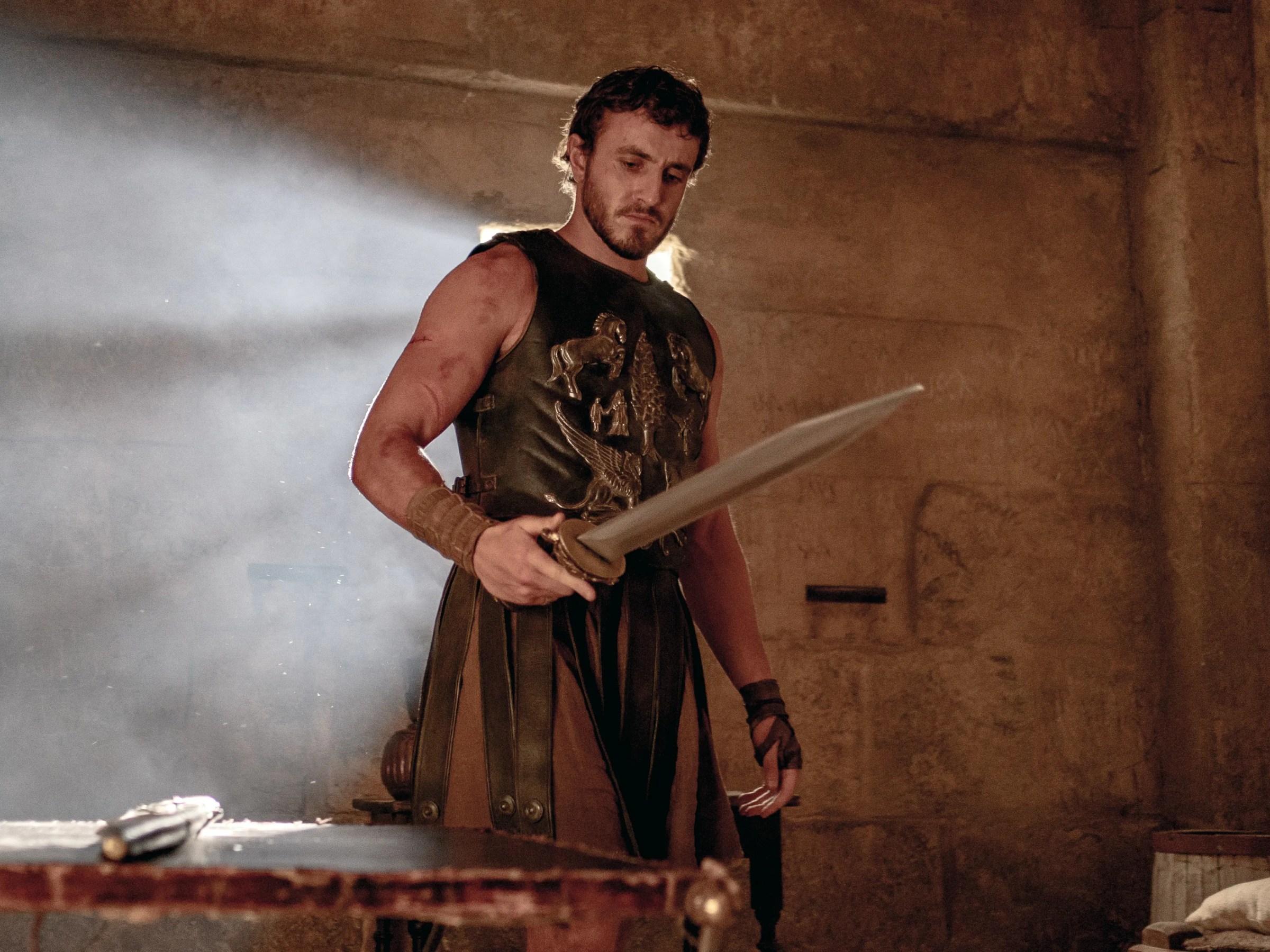 Paul Mescal con armadura de gladiador sosteniendo una espada en Gladiator II