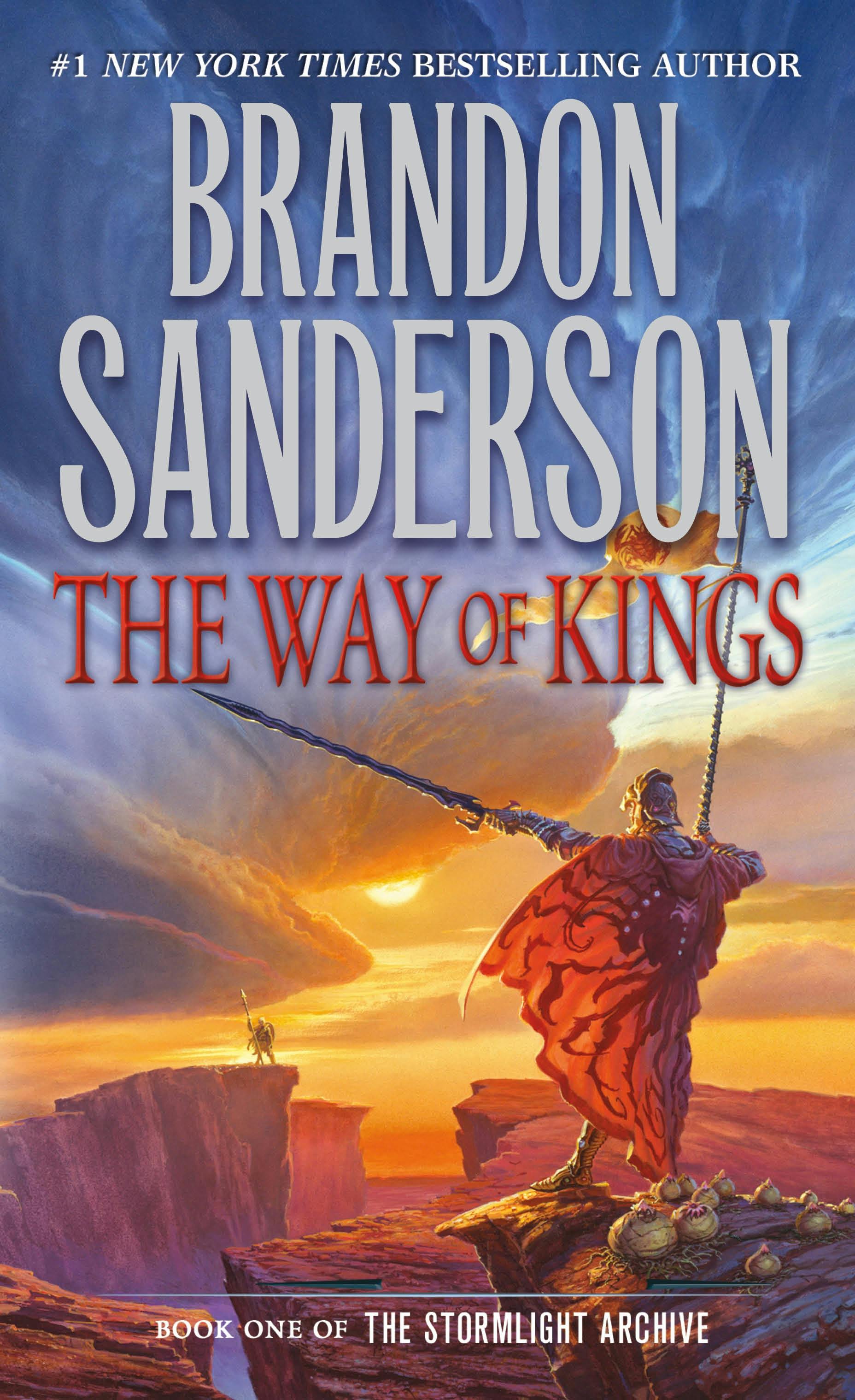 La portada de El Camino de los Reyes de Brandon Sanderson, con un hombre con armadura y una capa roja de pie sobre un acantilado, sosteniendo una lanza hacia arriba y apuntando a un cielo nublado.