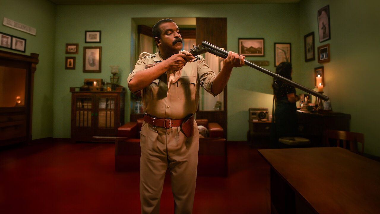 En The Rifle Club, un hombre vestido de beige inspecciona un rifle en una oficina.
