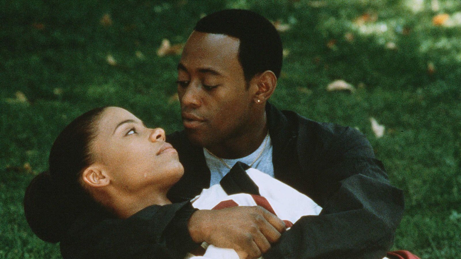 Una mujer (Sanaa Lathan) acostada en los brazos de un hombre (Omar Epps) en el amor y el baloncesto